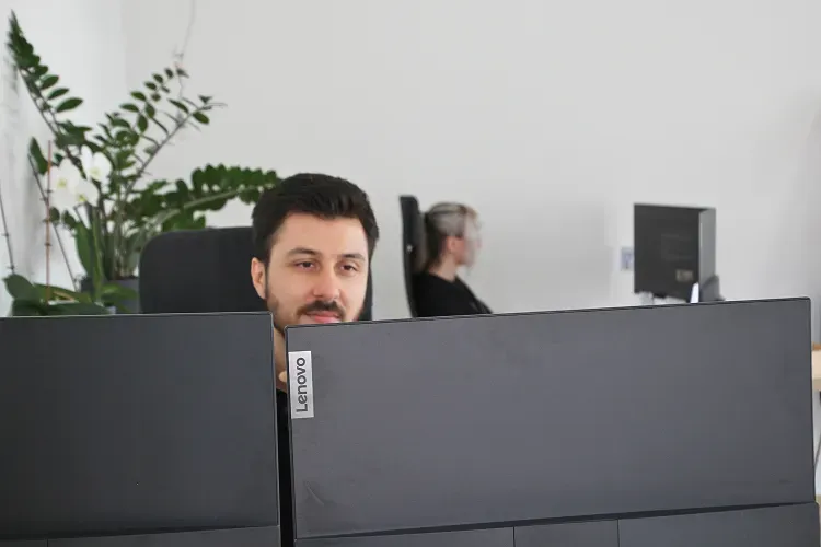 Zwei Mitarbeitende von Ipsom arbeiten an ihren Bildschirmen im Büro