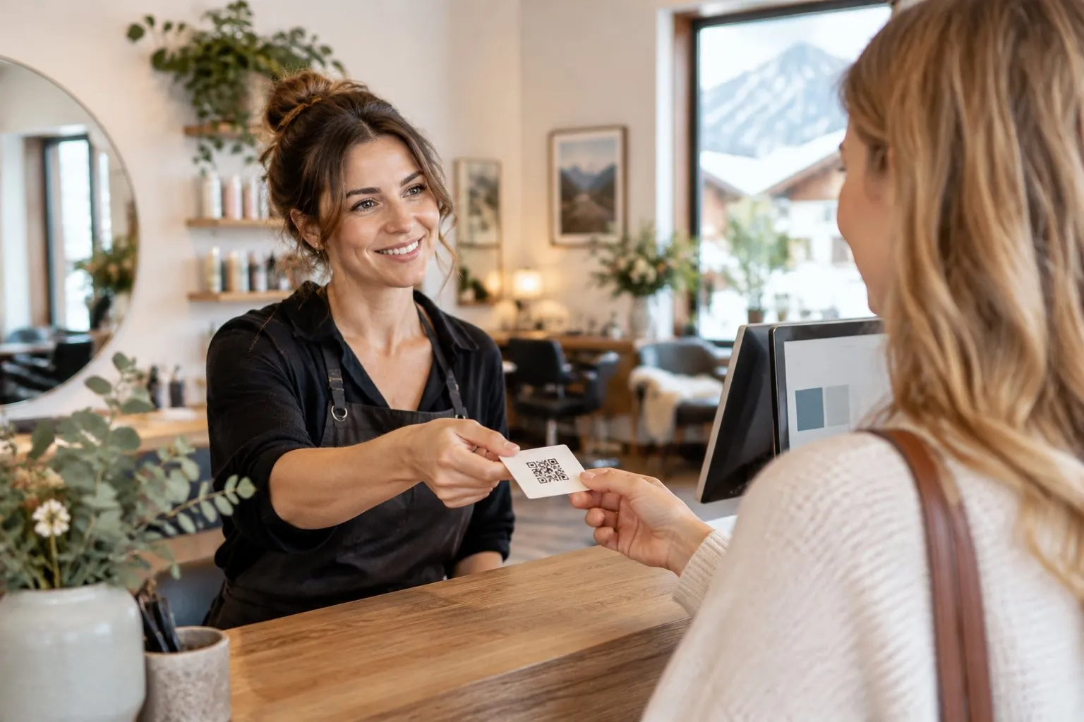 Friseurin gibt einer Kundin eine Karte mit QR-Code für eine Bewertung